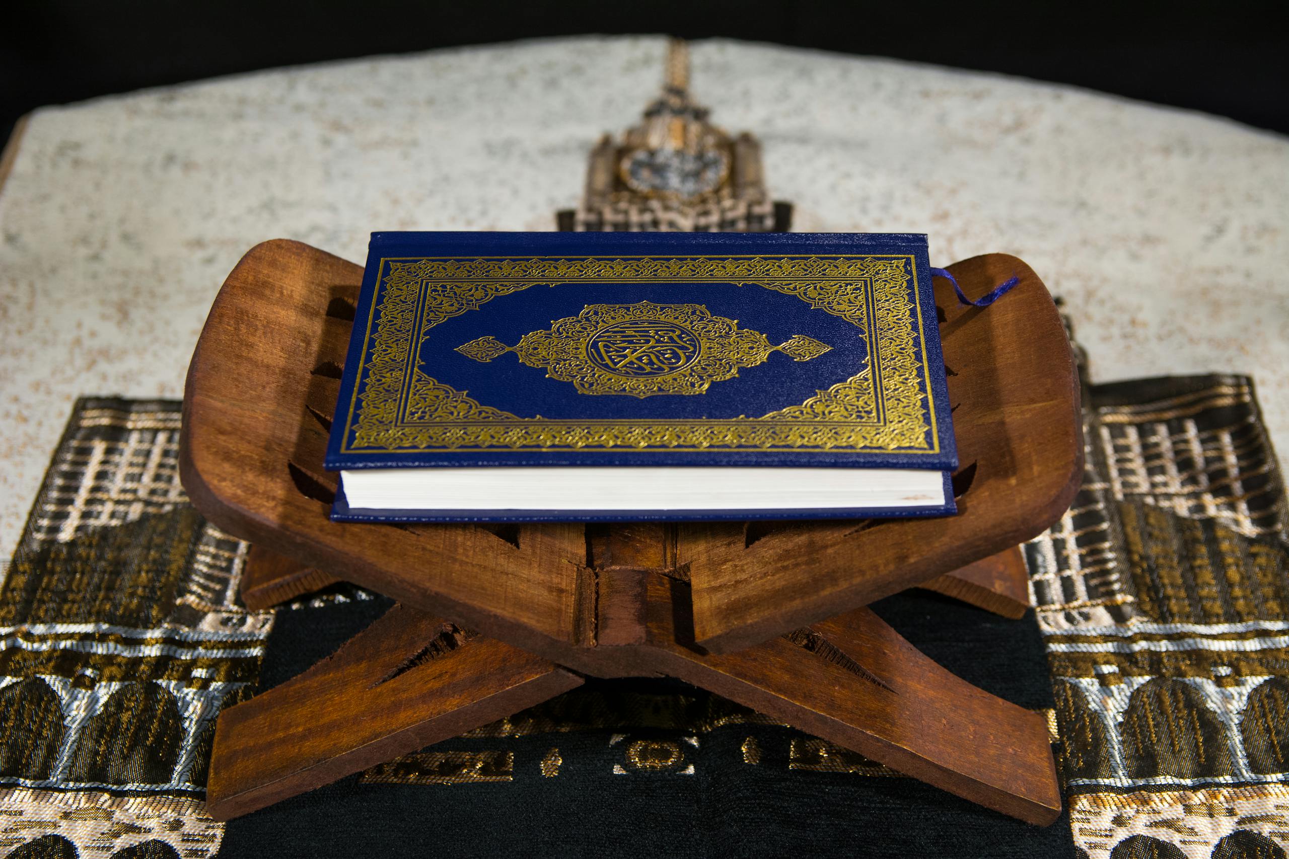 Close-up of the Quran on a wooden stand, symbolizing Islamic spirituality.